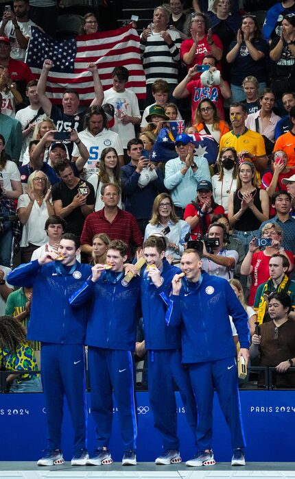 The crowd cheers members of the United States men's gold medal winning 4x100-meter freestyle...