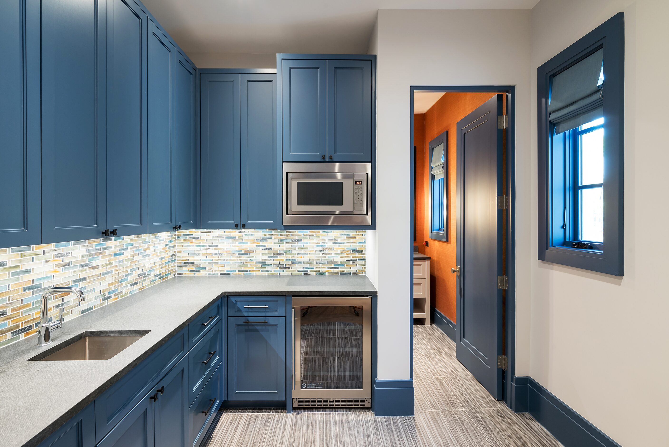 Blue cabinets in a snack bar offer colorful and practical storage in this space near the...