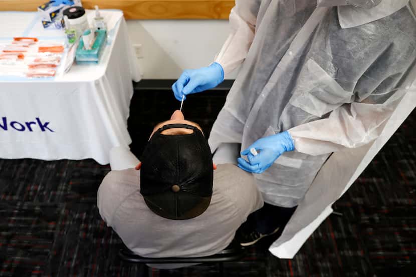 A Dallas Police officer is tested for COVID-19 by SafeWork medical assistant Angel Nunez at...