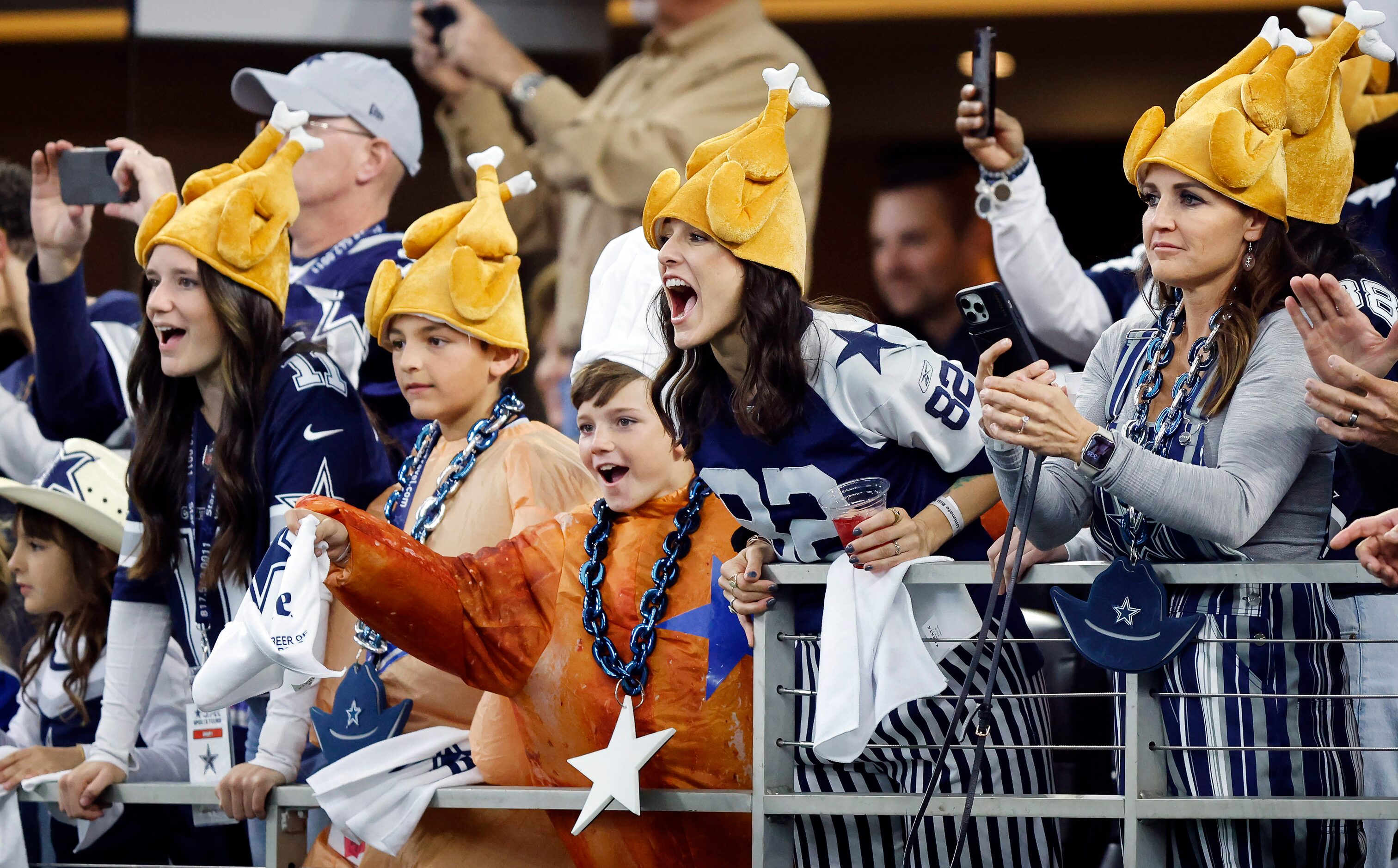 Dallas Cowboys fans dressed in Thanksgiving attire cheer for their team who faced the...