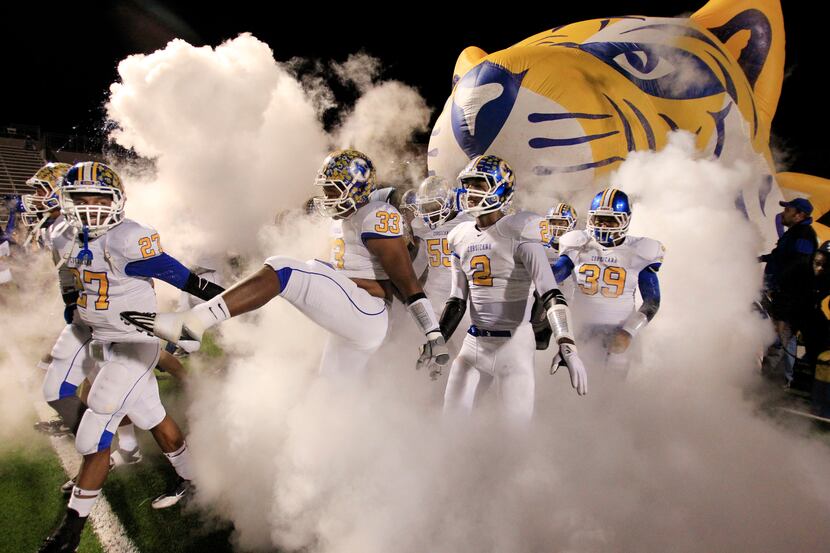 The Corsicana High Tigers enter the field in a cloud of smoke before an UIL high school...