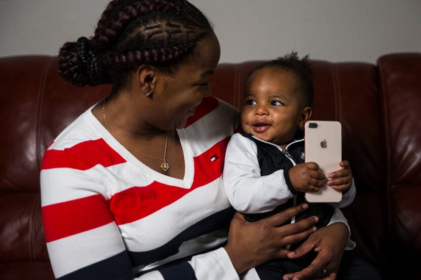 Ariel Murphy lets her 18-month-old son, Kairo, play with her cellphone at their home in...