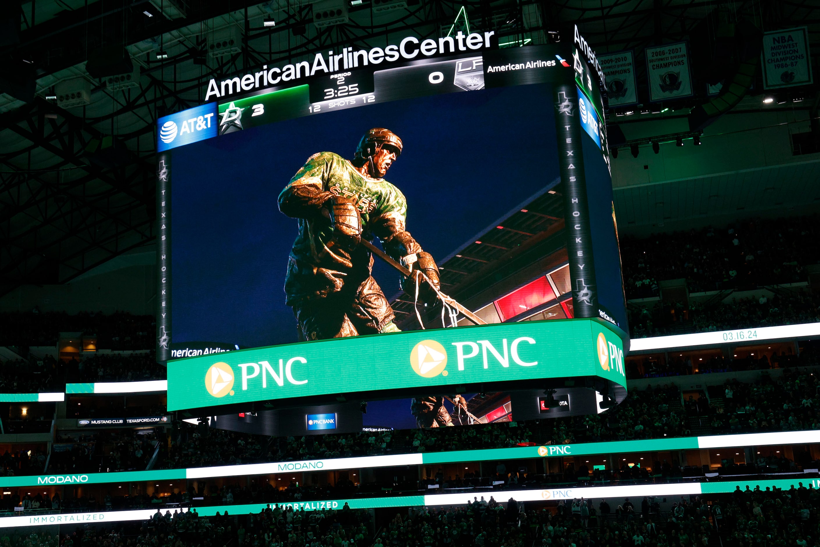 A big screen shows Dallas Stars legend Mike Modano’s statue during the unveiling ceremony of...