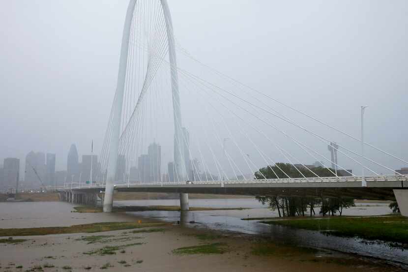 The Trinity River rises over its banks underneath the Margaret Hunt Hill Bridge in Dallas,...