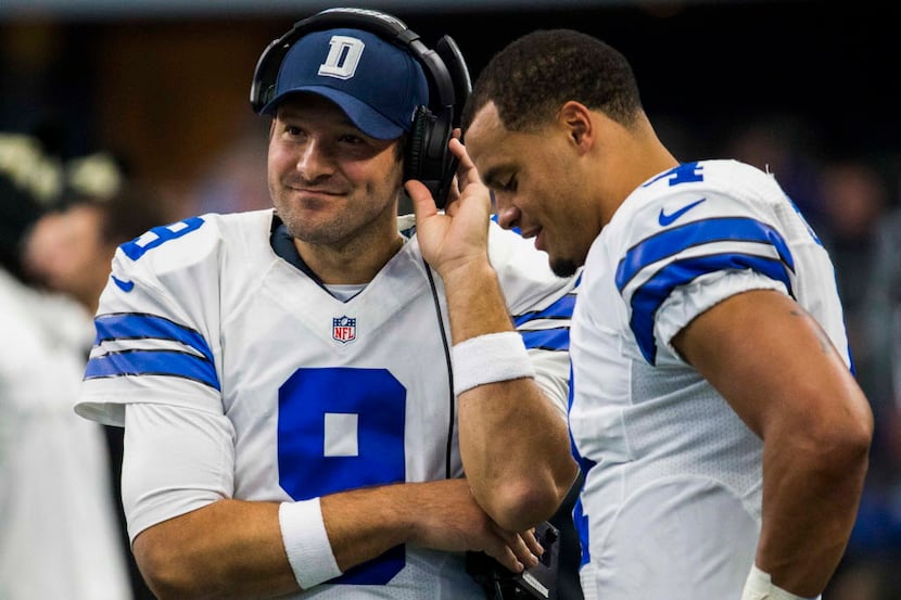 Cowboys quarterback Tony Romo (9) and quarterback Dak Prescott (4) talk on the sideline...