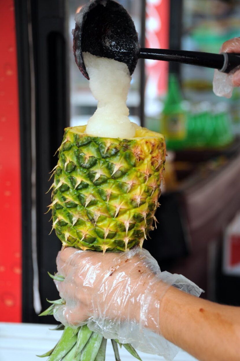 A pina colada is served in a pineapple at Rusas at Taste of Dallas.