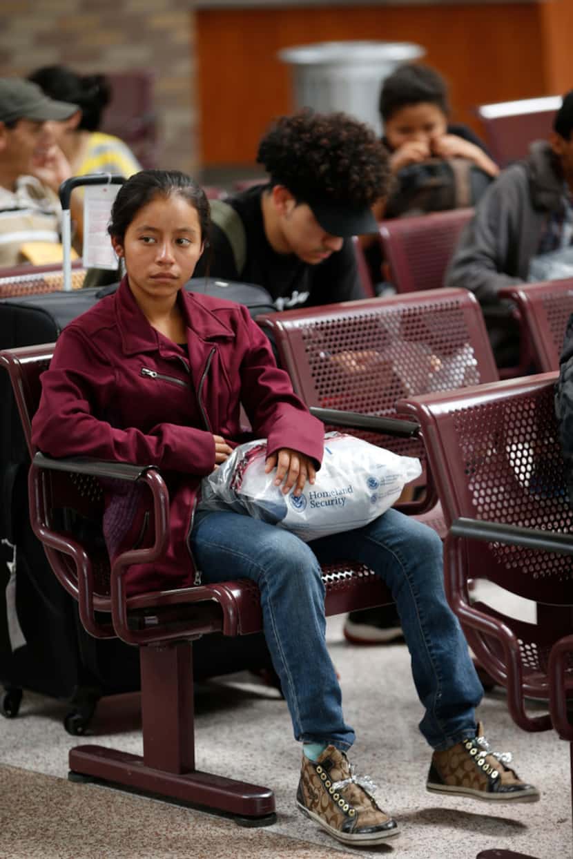 Claudia Xol, 16, waits at the bus stop after being dropped off by federal immigration staff...