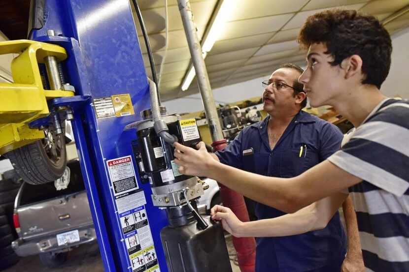 Joaquín Godínez (izq.) y su hijo Cristian, de 14 años, trabajan en su taller mecánico de...