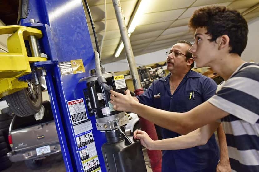 Joaquín Godínez (izq.) y su hijo Cristian, de 14 años, trabajan en su taller mecánico de...