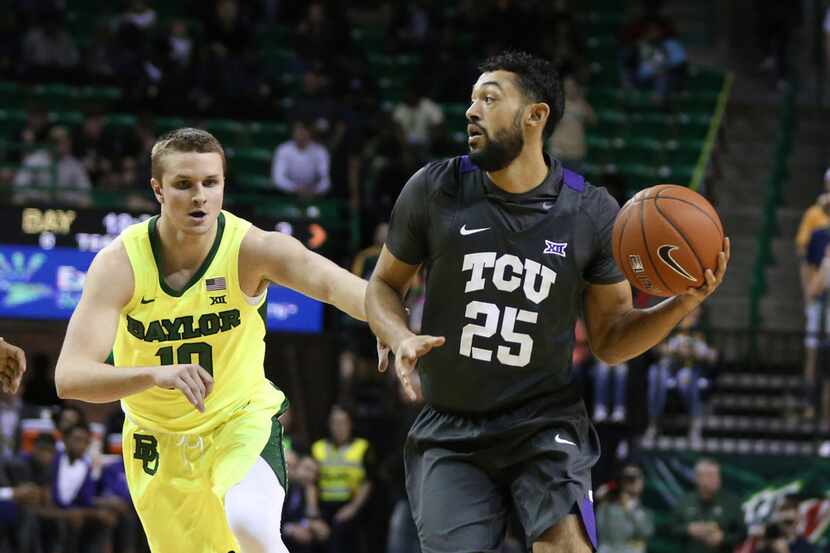 TCU guard Alex Robinson, right, drives around Baylor guard Makai Mason, left, in the first...