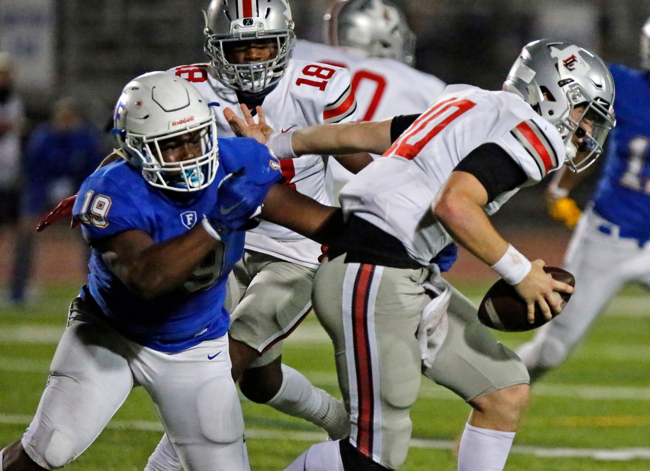 Lovejoy High School quarterback R.W. Rucker (10) is chased by Frisco High School defensive...