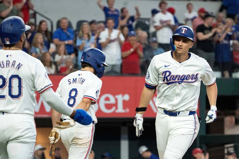 The Rangers' Corey Seager was congratulated by Ezequiel Duran (20) after hitting a two-run...