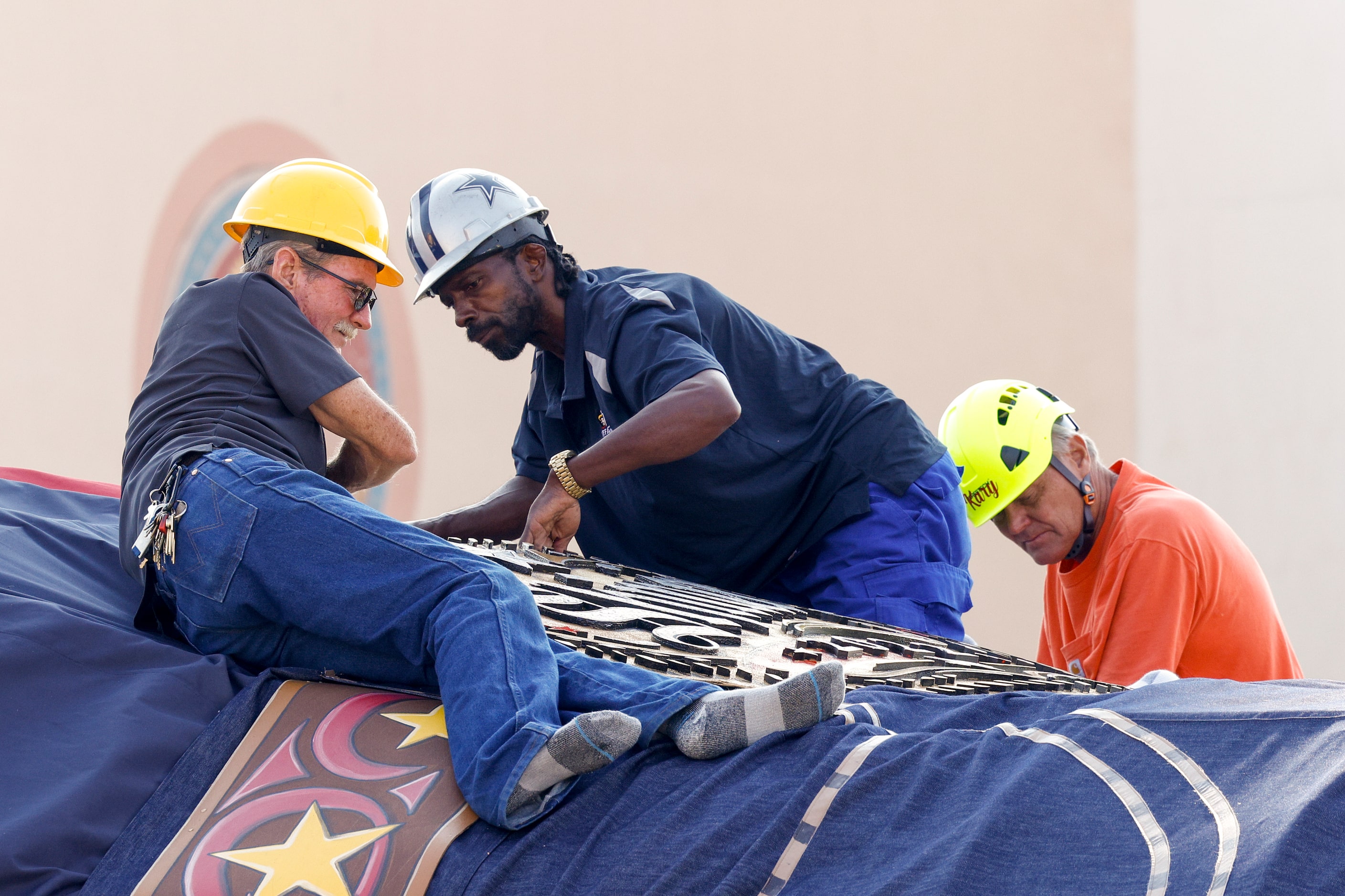 Crews work to install Big Tex’s Shiner beer belt buckle at The State Fair of Texas, Friday,...