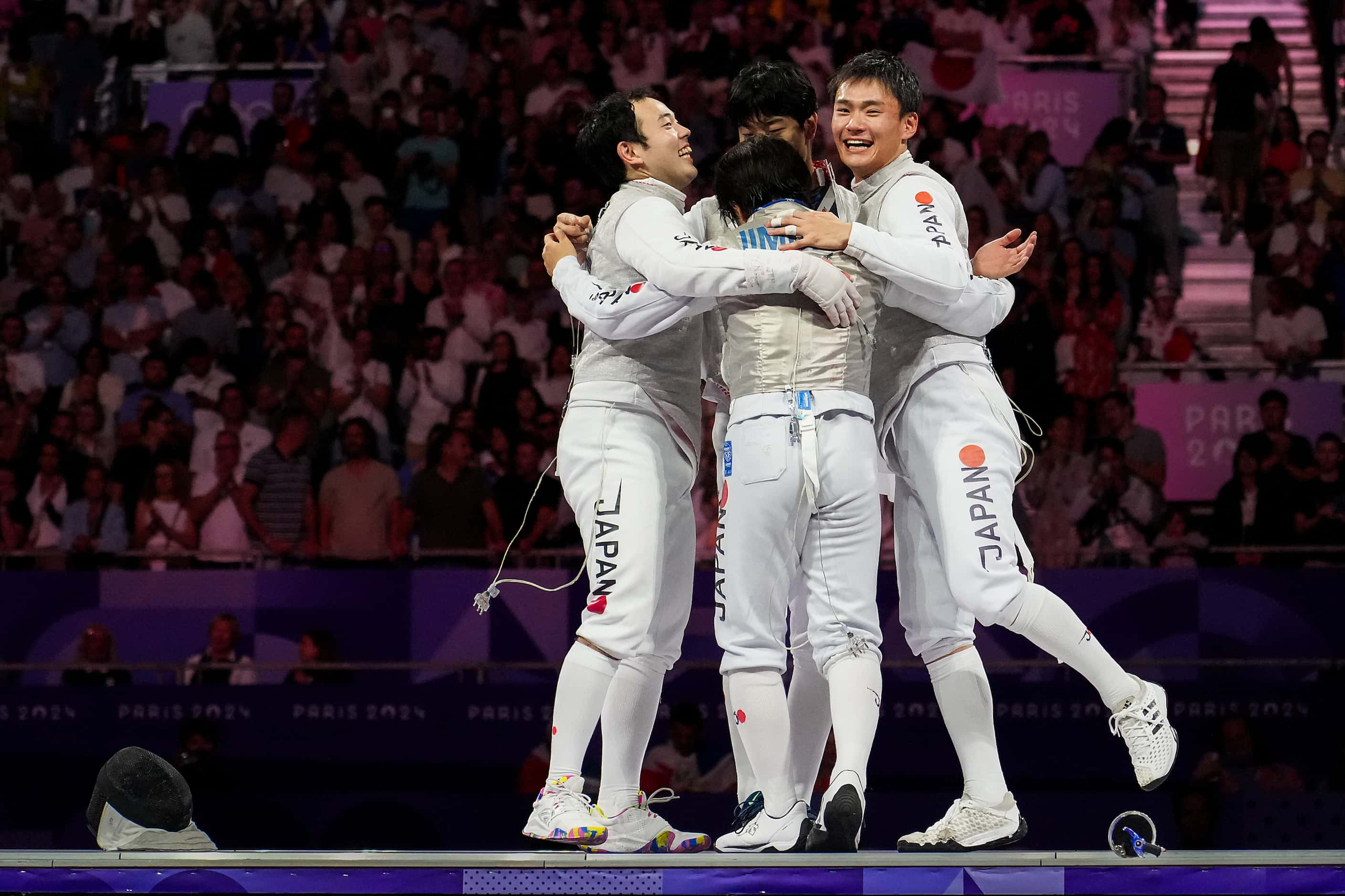 Team Japan celebrates after a victory over Italy in the men’s foil team gold medal match at...