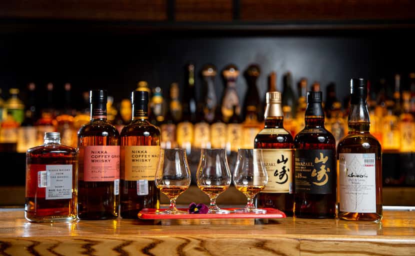 Three flights of Nikka Coffey Grain Whisky flanked by bottles of various Japanese whiskies...