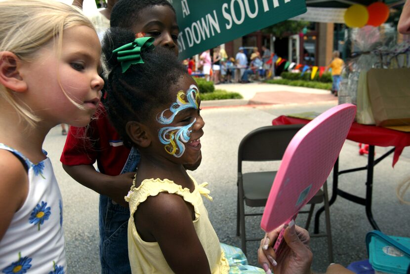 Nola Grace Wilson (R), 3, of Denton, smiles at her reflection in a mirror after seeing her...