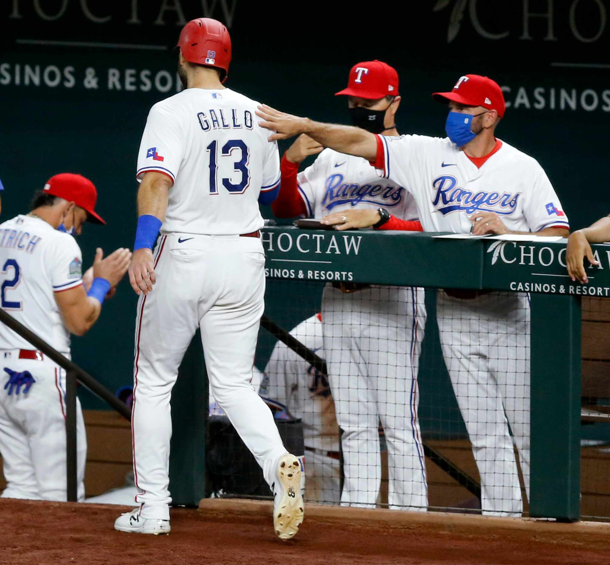 Texas Rangers Joey Gallo (13) is congratulated by manager Chris Woodward after scoring on a...