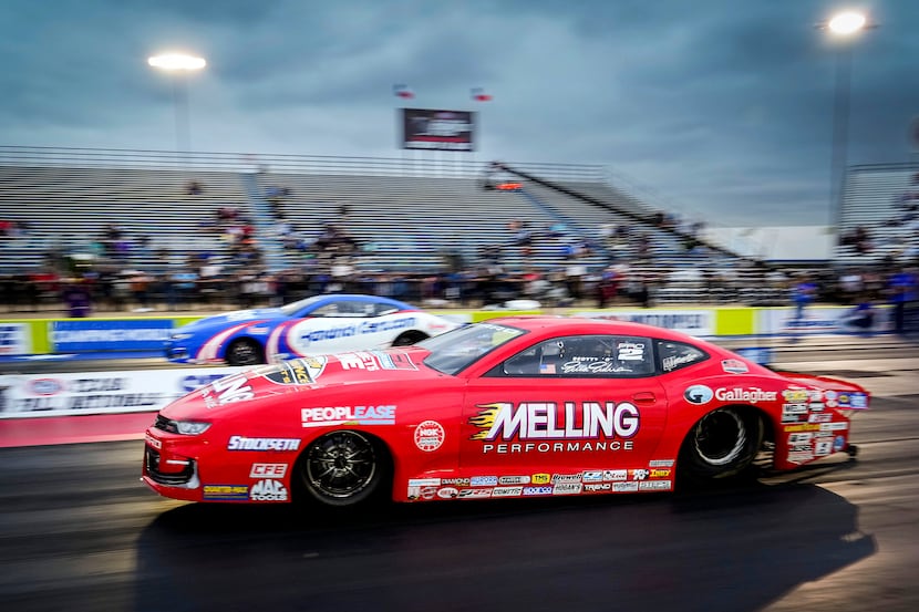 Erica Enders	(front) comes off the line in her Pro Stock victory over Greg Anderson (top) at...