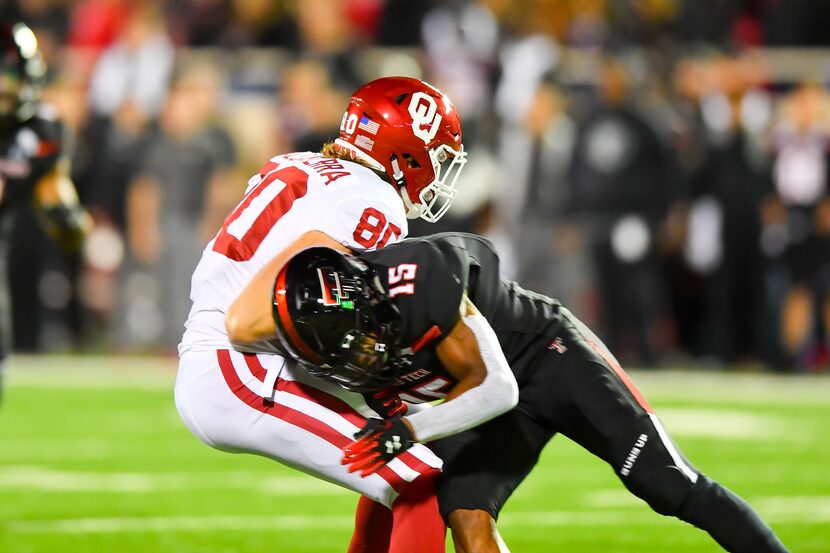 LUBBOCK, TX - NOVEMBER 03: Grant Calcaterra #80 of the Oklahoma Sooners takes a hard hit...