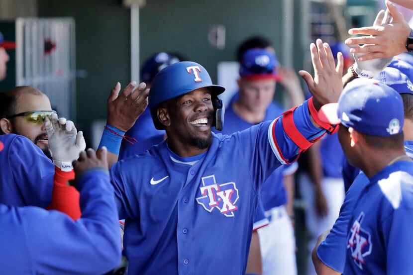 Texas Rangers' Adolis Garcia is congratulated in the dugout after hitting a solo home run...