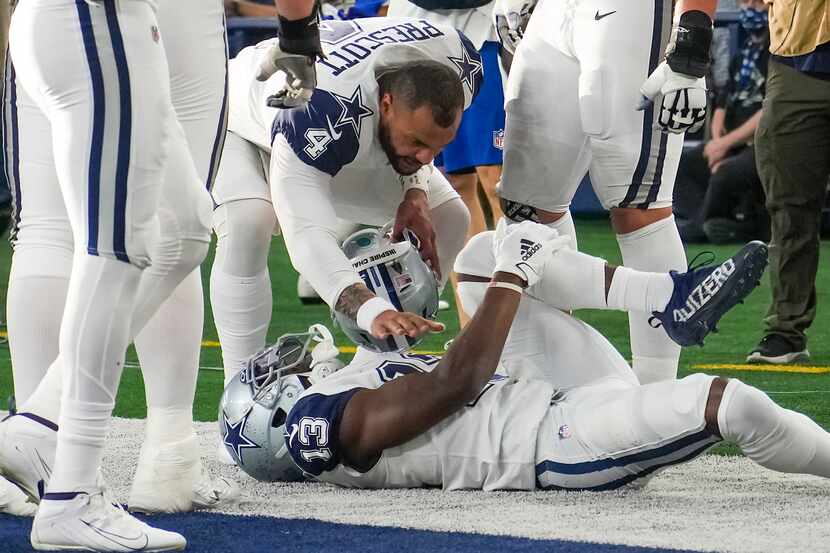 El receptor de los Cowboys de Dallas se duele  de su rodilla izquierda tirado en el césped...