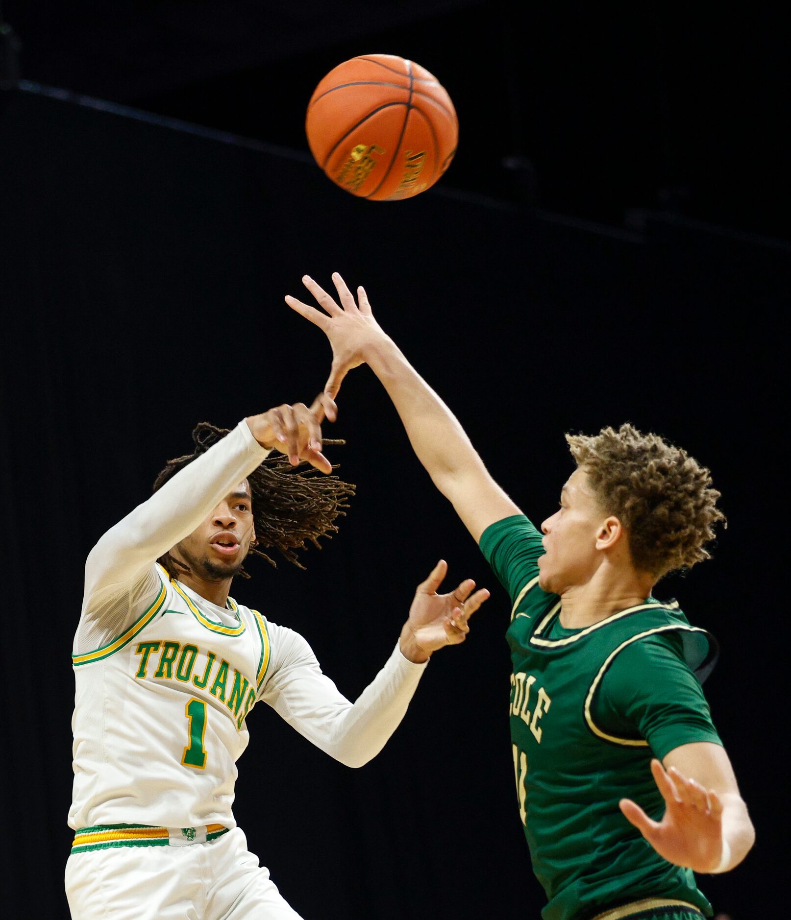 Madison guard Phil Thomas (11) jumps and passes the ball over San Antonio Cole guard Trey...