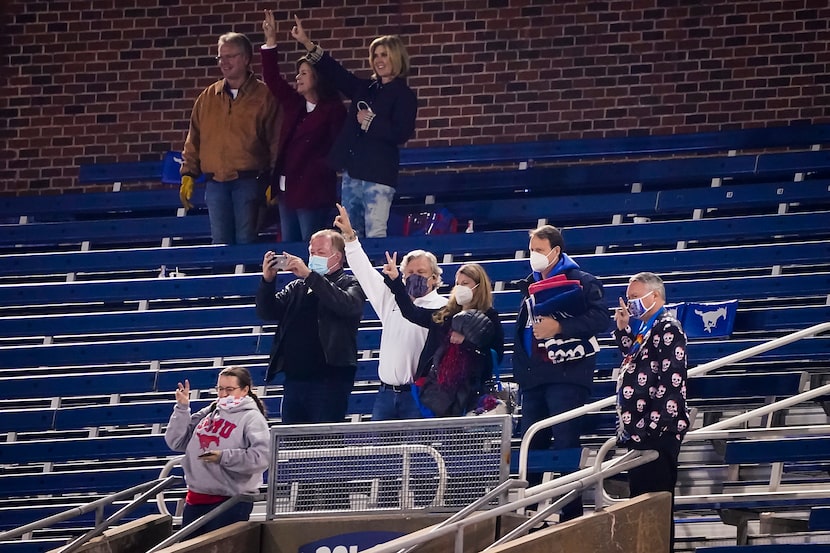 SMU fan Paul Layne (center. in white shirt) stands for the playing of the school’s alma...