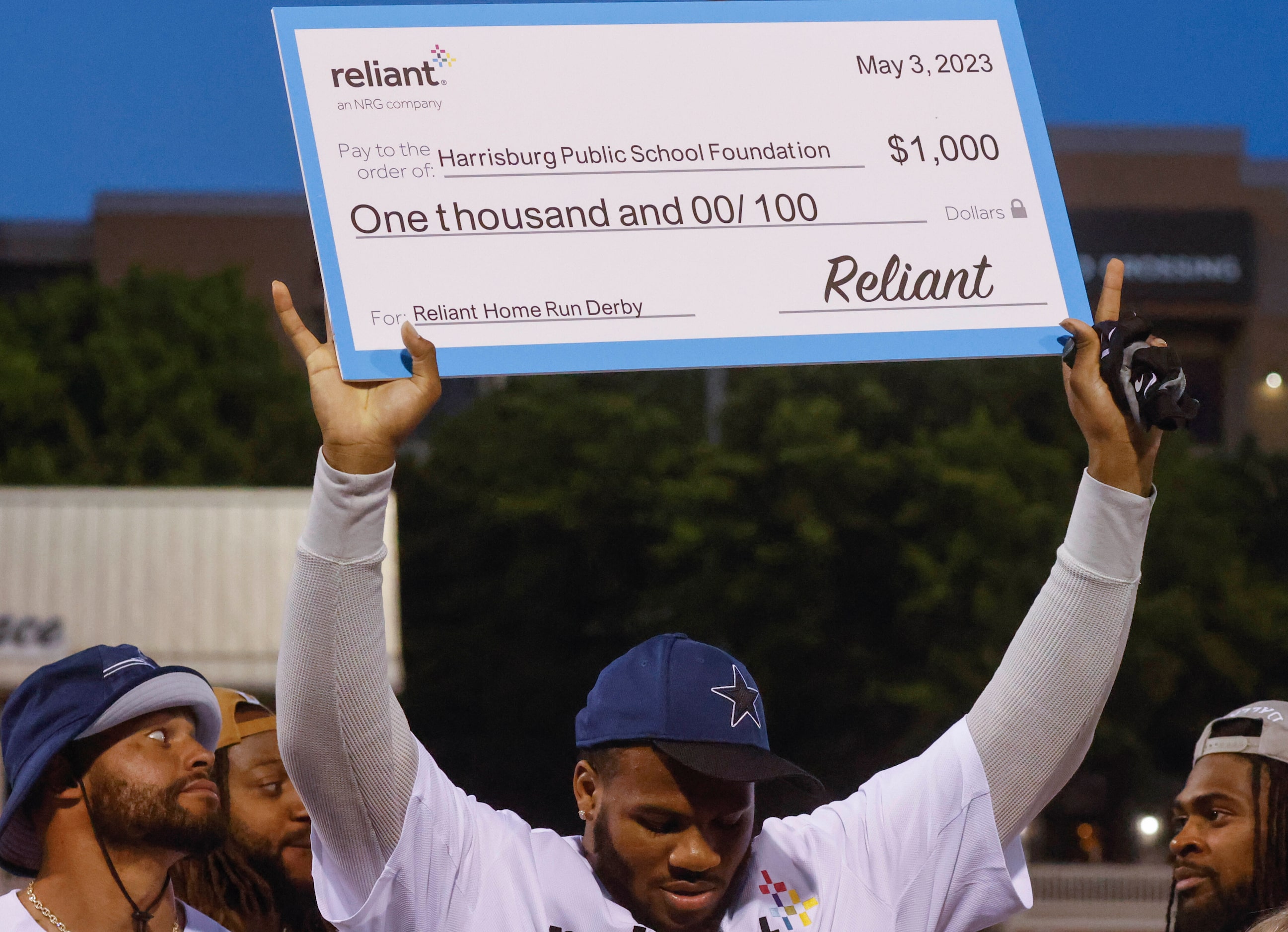 Dallas Cowboys linebacker Micah Parsons lifts a prize money cheque during the presentation...