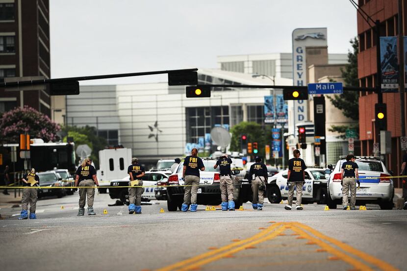 DALLAS, TX - JULY 09:  Members of an FBI evidence response team search an area that is still...