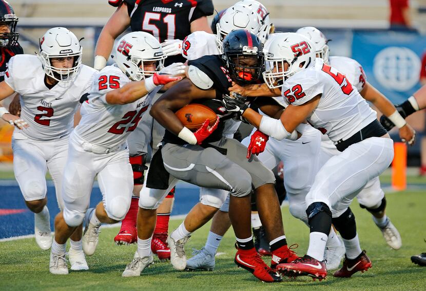 Lovejoy running back Jahi Rainey (28) is met by a host of defenders led by Argyle linebacker...