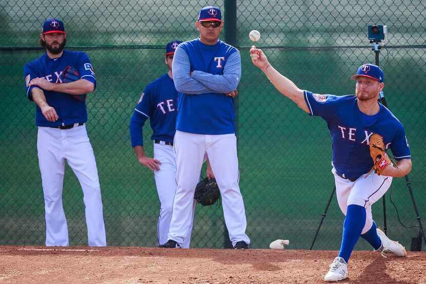 Texas Rangers pitcher Shelby Miller throws in the bullpen as pitching coach Julio Rangel...