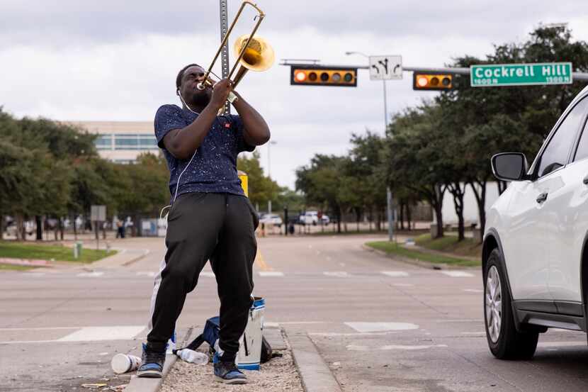 Joshua Reese, de 23 años, toca su trombón en la esquina de North Cockrell Hill Road y DFW...