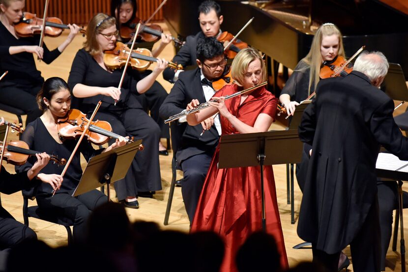 Music director Paul Phillips (right) conducts as flute soloist Kara Kirkendoll Welch (left)...