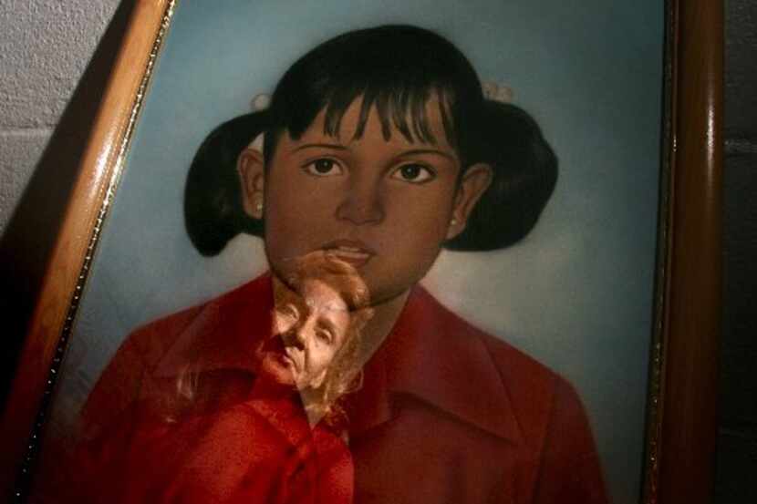 Rosa Maria Clarke is reflected in a portrait of her daughter Vanessa Villa.