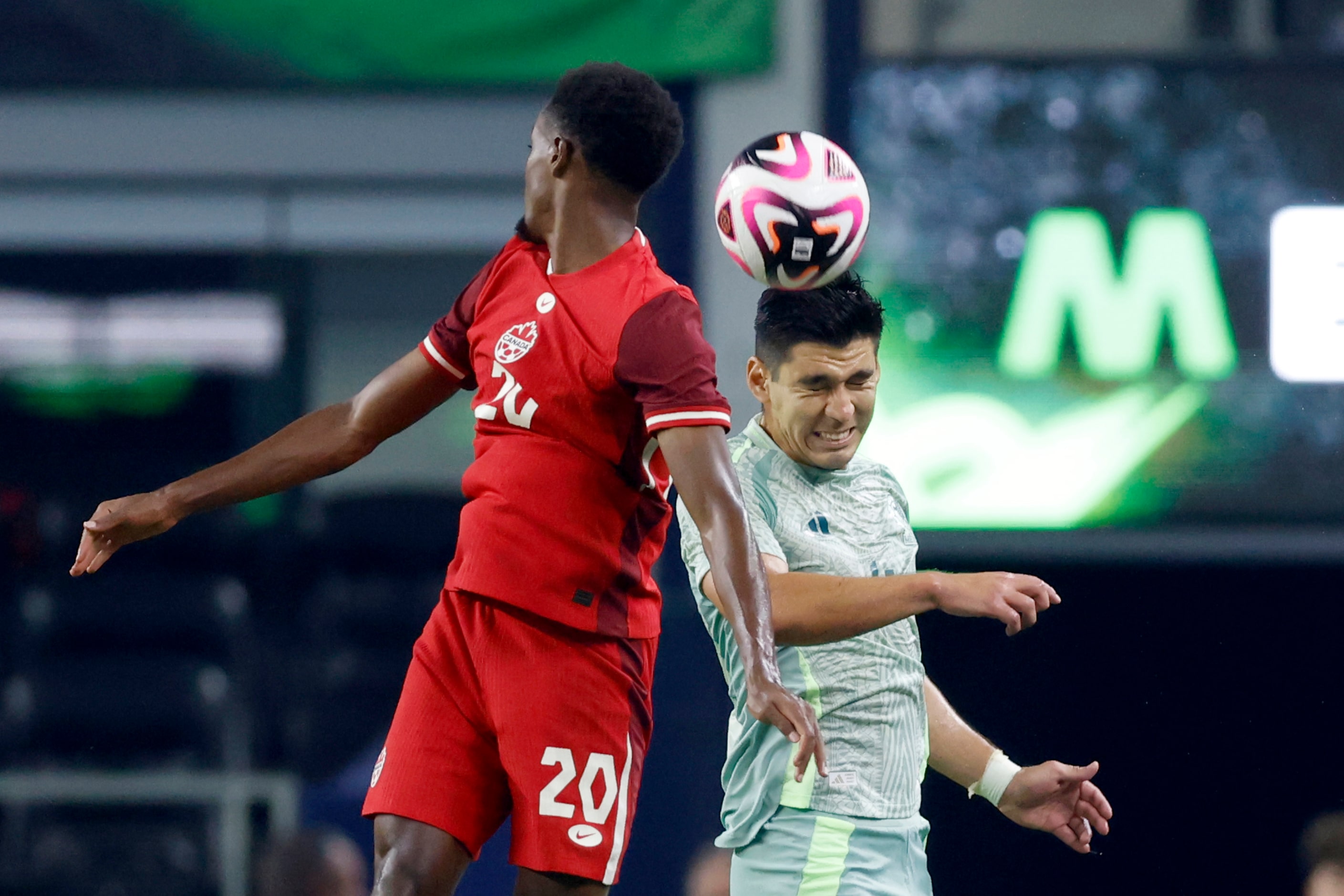 Mexico defenseman Jesus Angulo (4) heads the ball alongside Canada Ali Ahmed (20) during the...