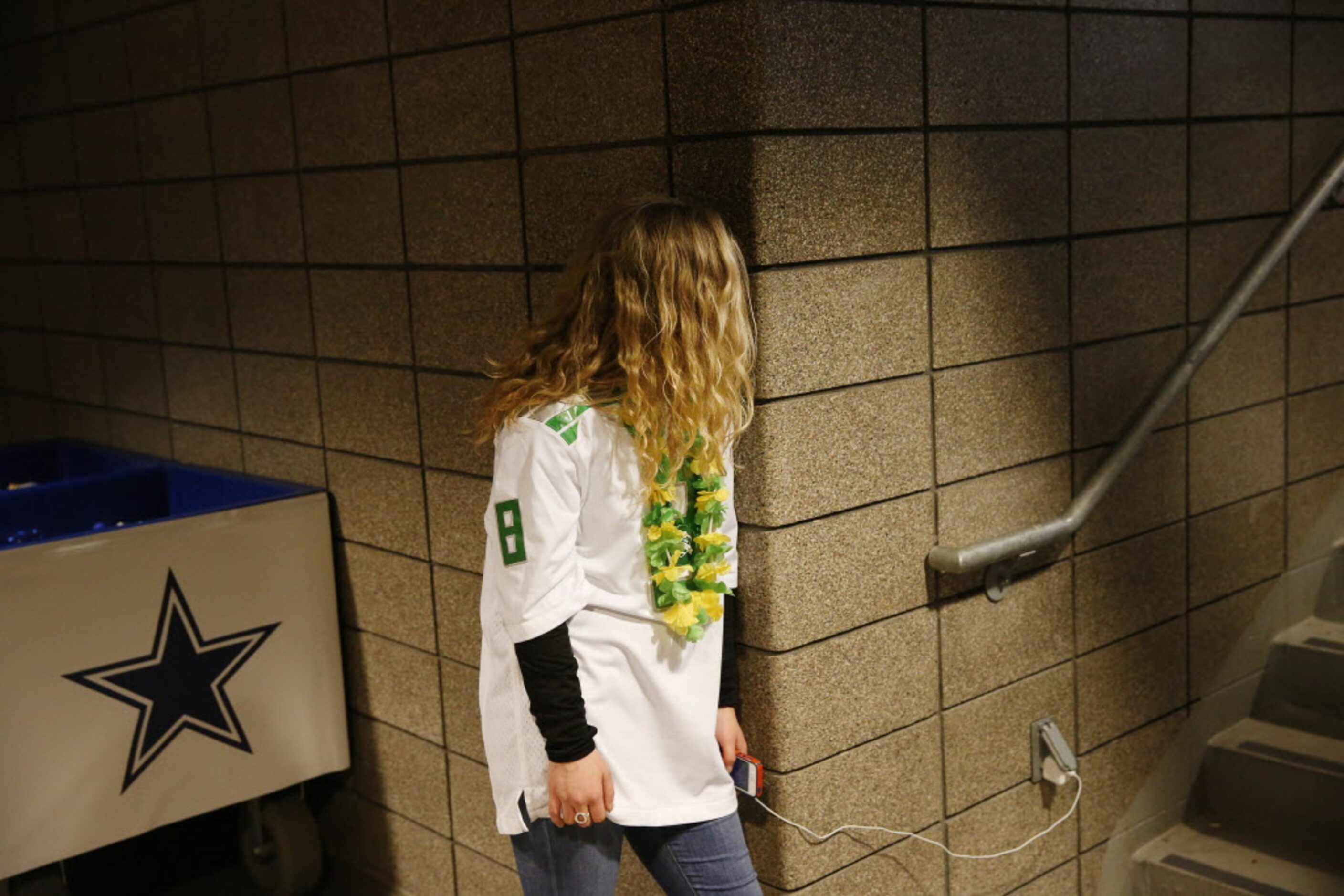 Oregon Ducks fan Maddie Terefenko, of Eugene, Oregon, watches the game while she charges her...