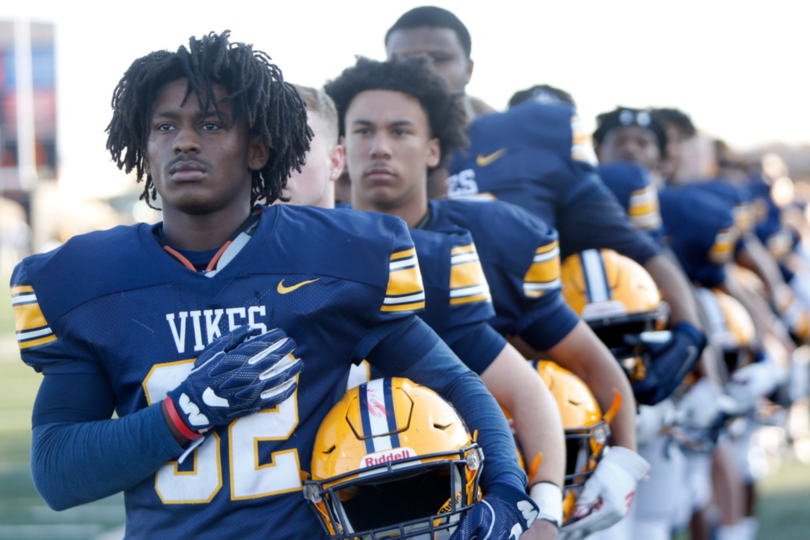 Arlington Lamar linebacker Jerry Hood (32) pauses with teammates for the playing of the...