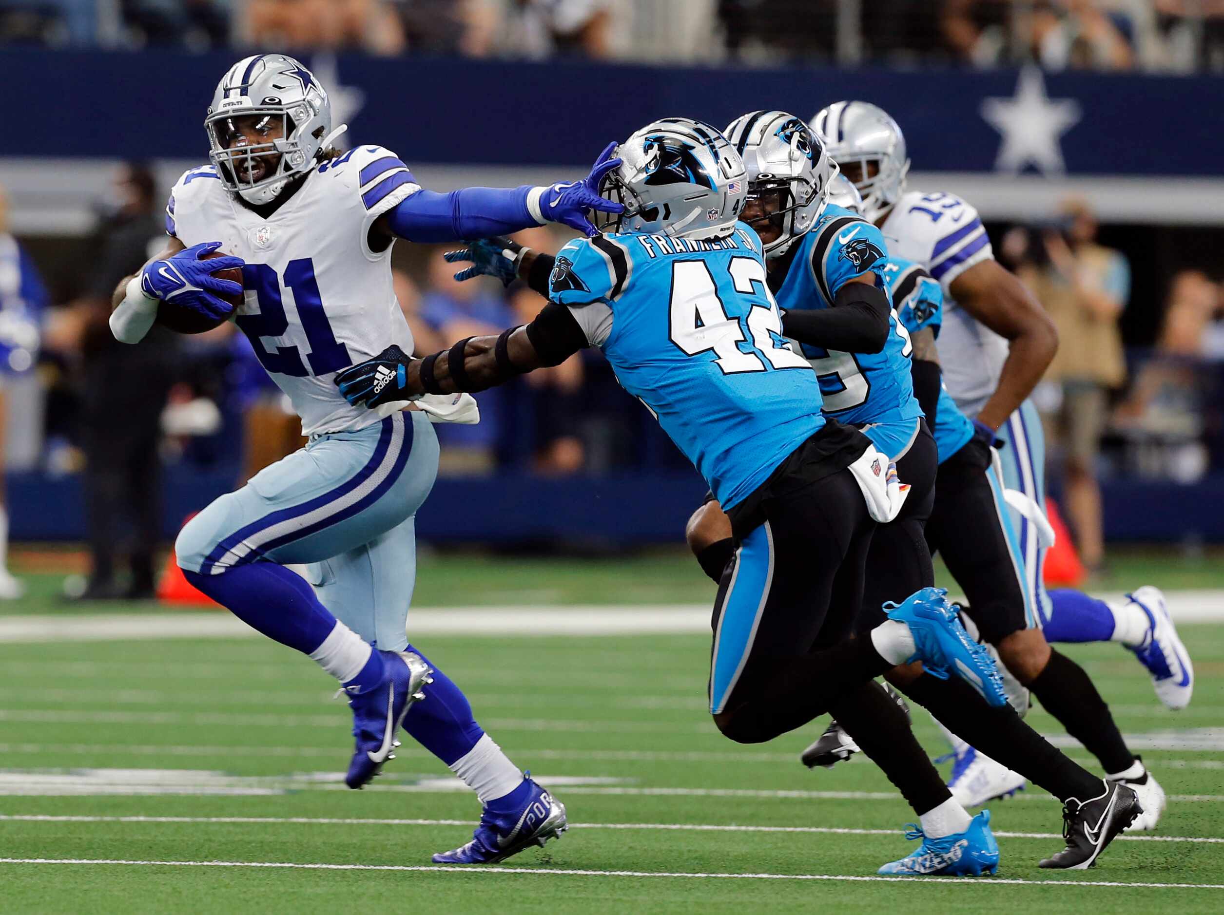 Dallas Cowboys running back Ezekiel Elliott (21) straightarms Carolina Panthers safety Sam...