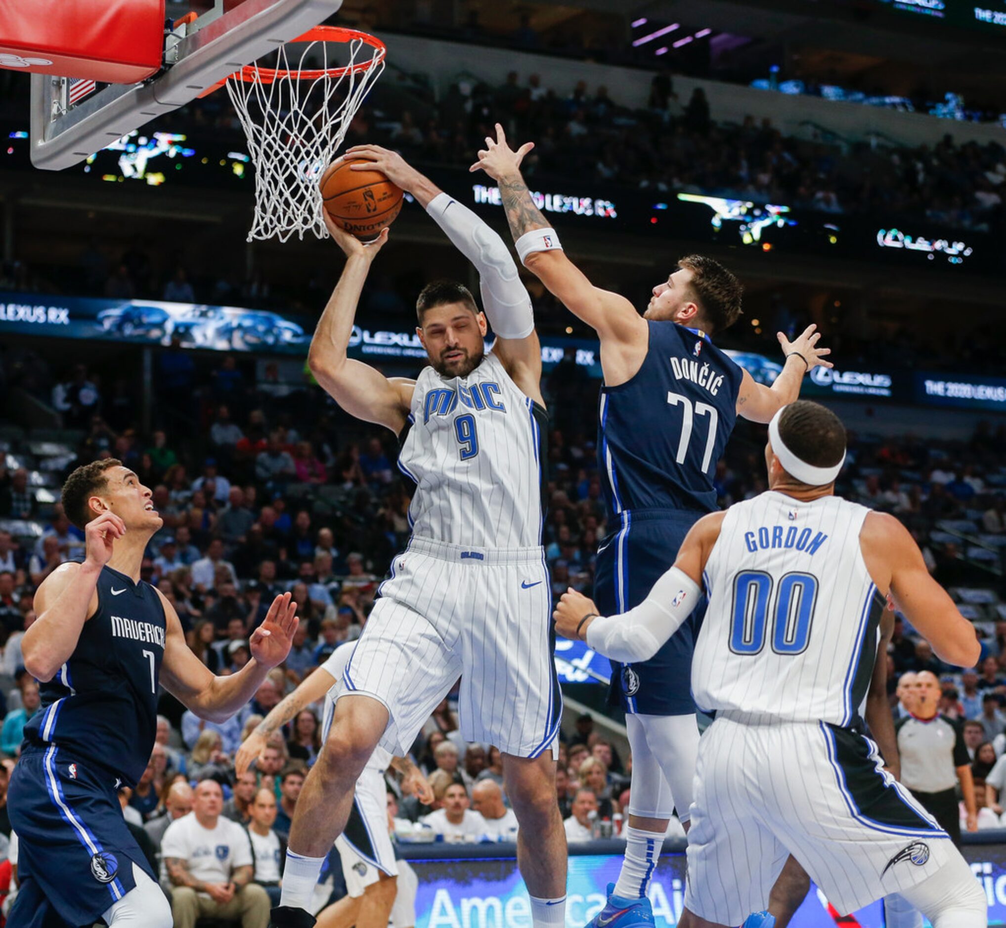 Orlando Magic center Nikola Vucevic (9) brings down a rebound past Dallas Mavericks guard...