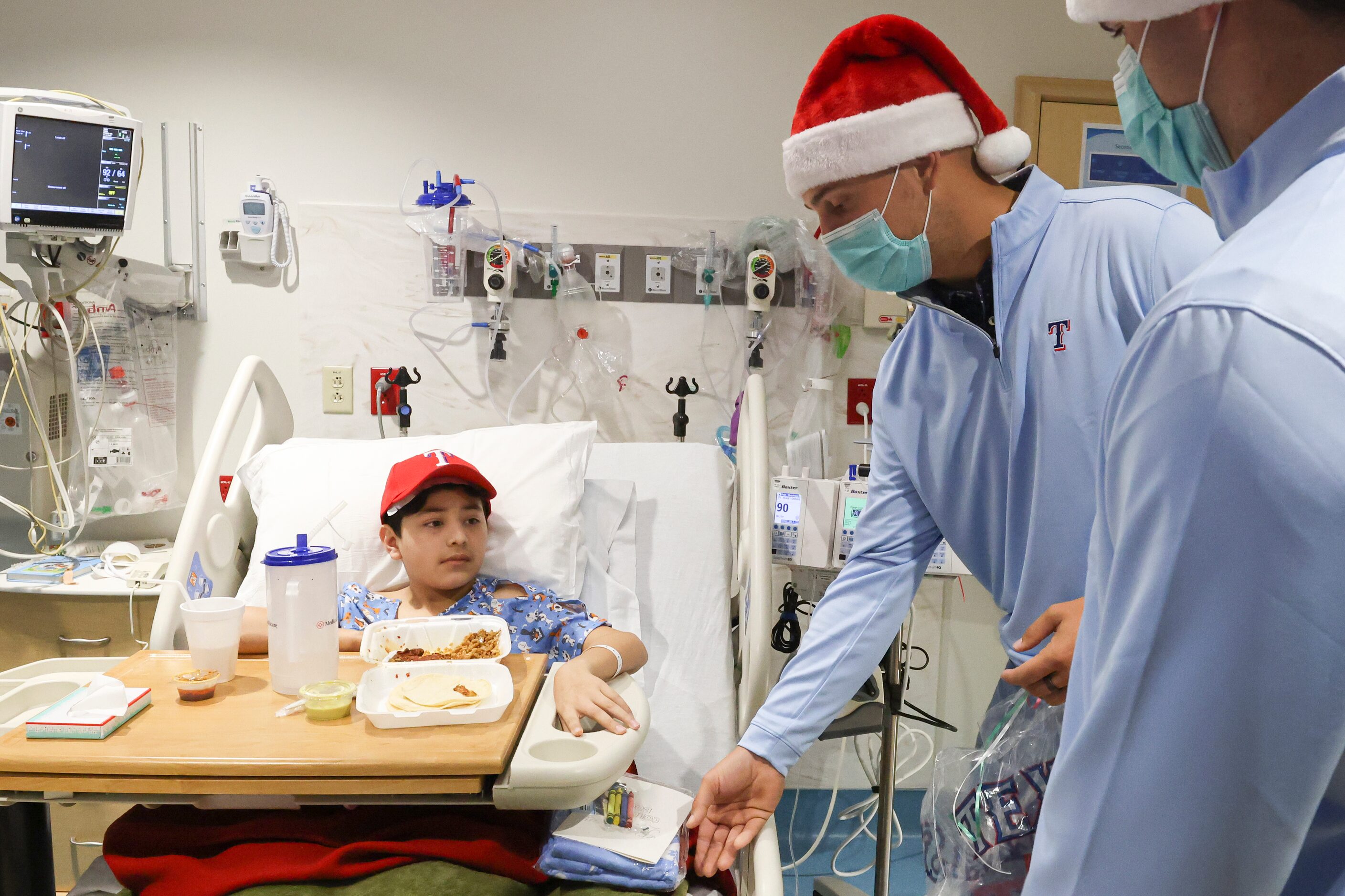 Texas Rangers first baseman Nathaniel Lowe gives Angel Mata, 10, a gift at Medical City...