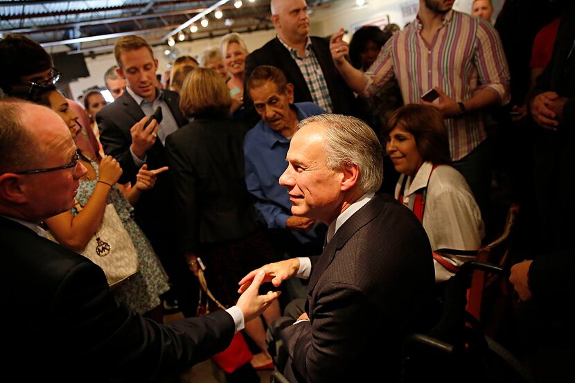 
Texas Gov. Greg Abbott (center) shakes hands with State Rep. Kenneth Sheets, R-Dallas, at...