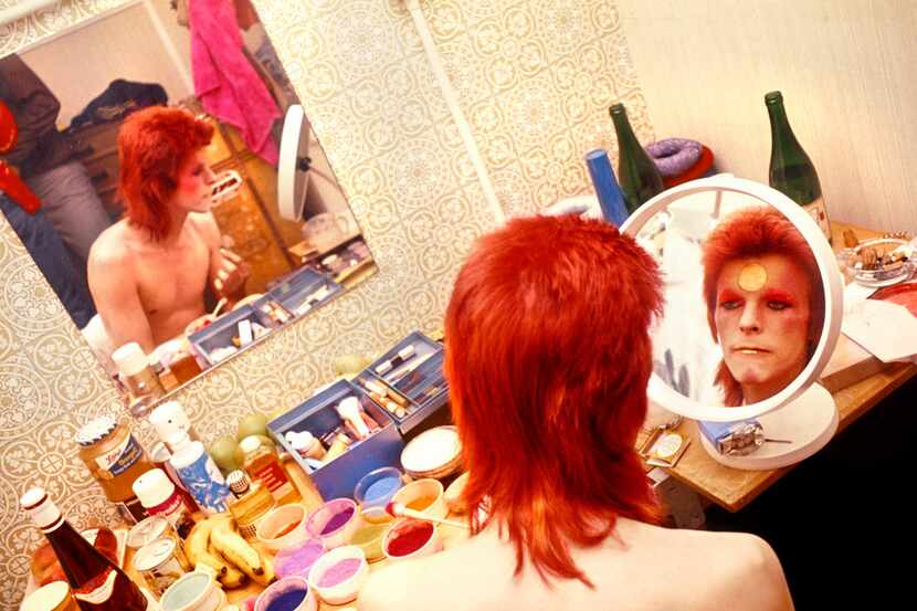 David Bowie uses a mirror to apply makeup in Scotland in 1973.