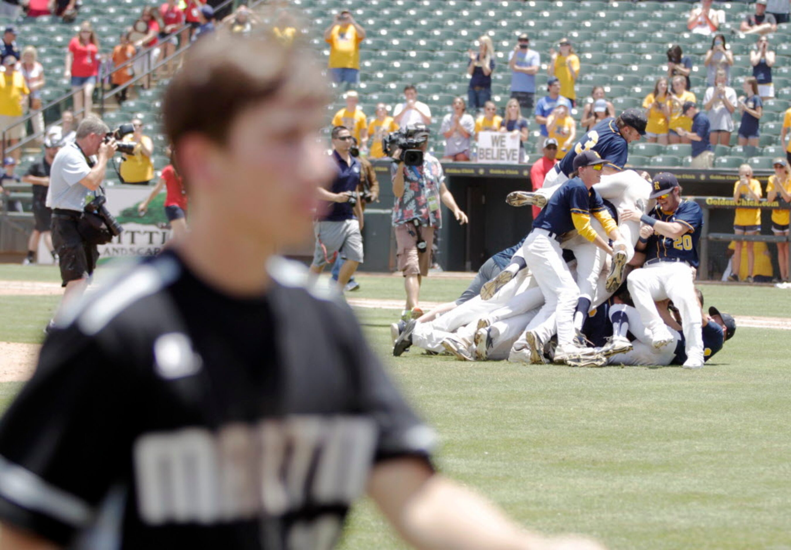 Cypress Ranch celebrates a victory as Martin's Stuart Stone (20) makes his way to the dugout...