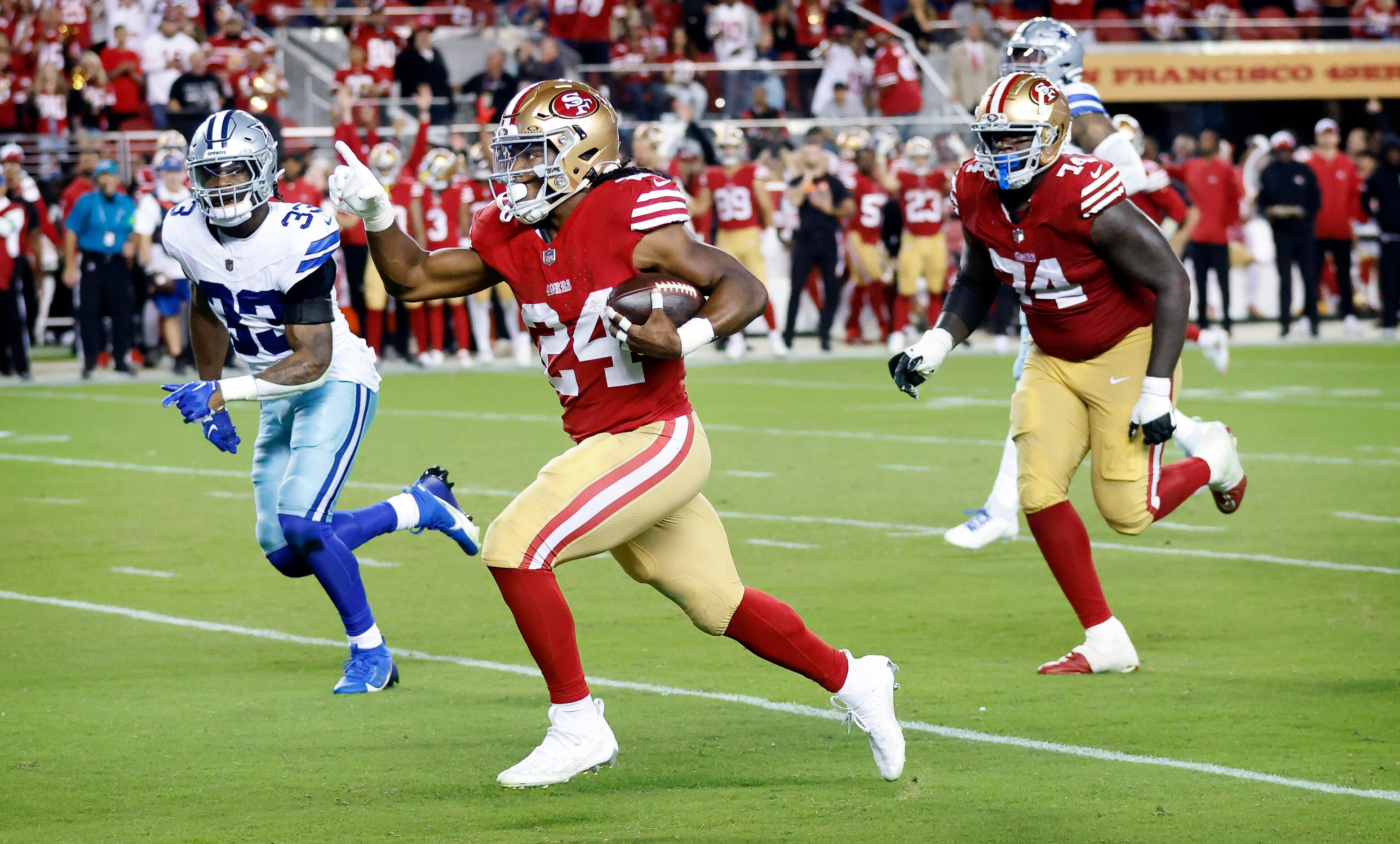 San Francisco 49ers running back Jordan Mason (24) points the way to the end zone after he...