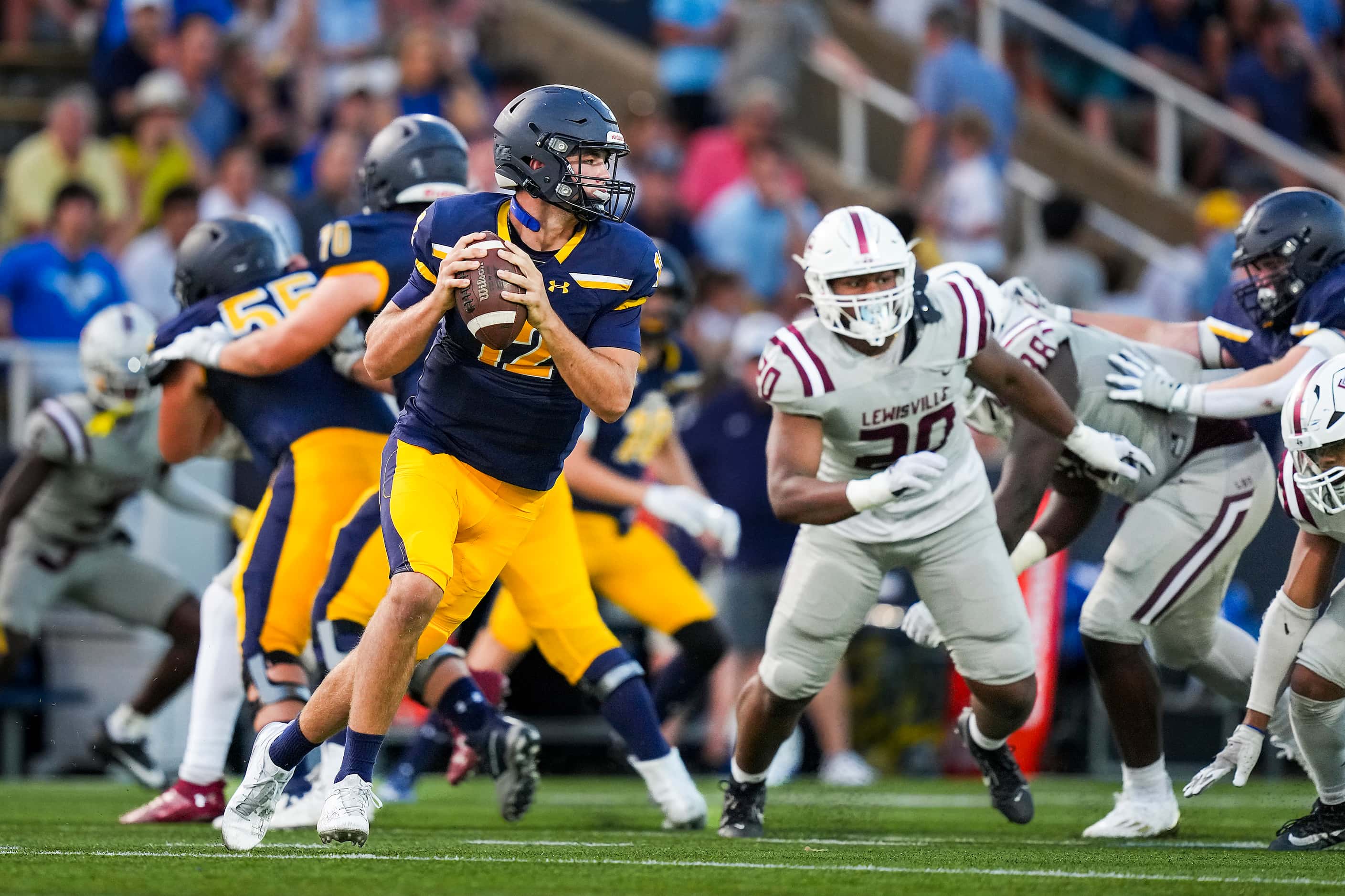Highland Park quarterback Warren Peck (12) rolls out away from the Lewisville rush during...