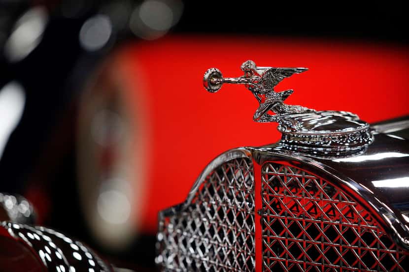 The red carpet is reflected in the hood ornament and grill to a 1932 Packard Eight 902 Coupe...