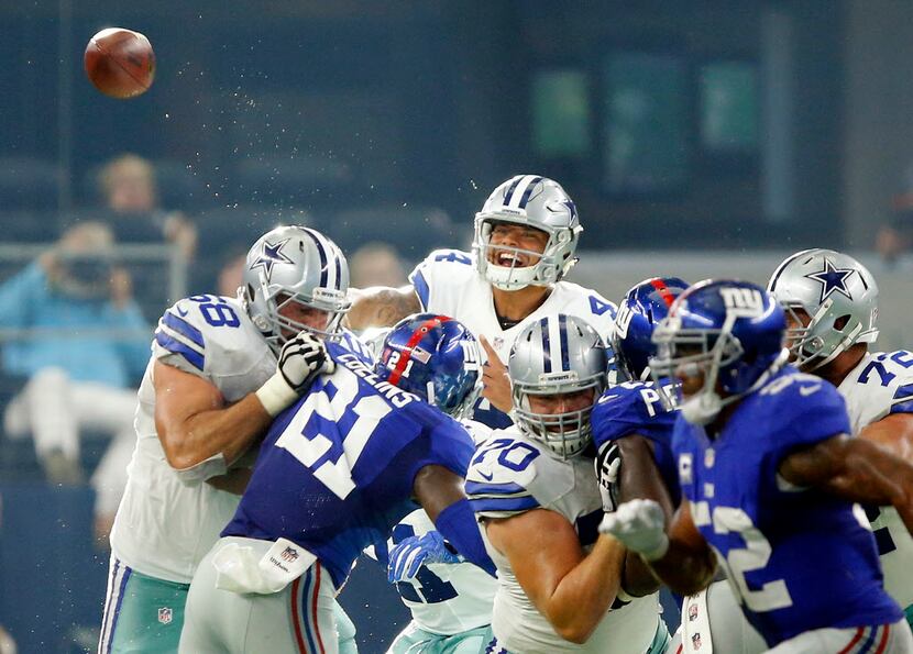 Dallas Cowboys quarterback Dak Prescott (4) tosses a pass over the New York Giants line...