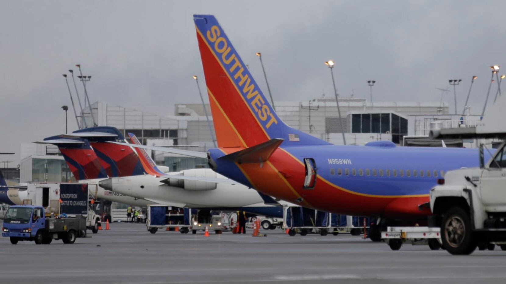 Planes belonging to Southwest Airlines, right, and Delta Air Lines, left, are parked at...