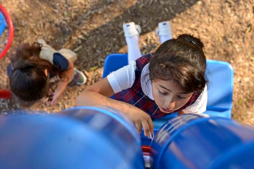 
Giselle Mariscal, 7, plays “house” on the playground after school at the Bataan Community...