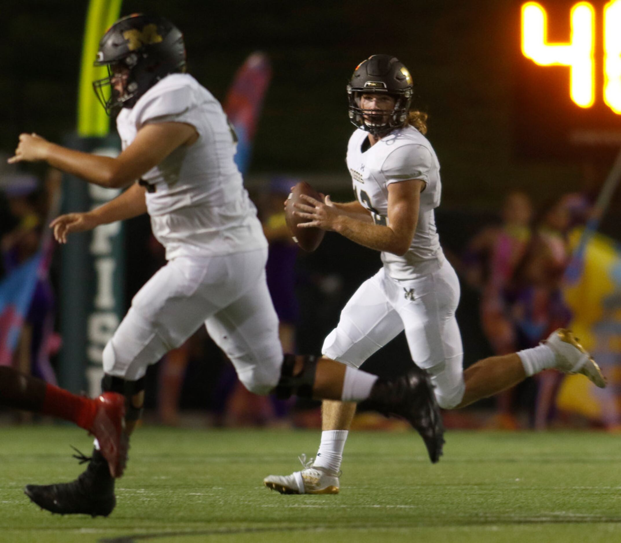 Mansfield quarterback Hunt Young (12) stays in step with Tigers offensive lineman Cole...